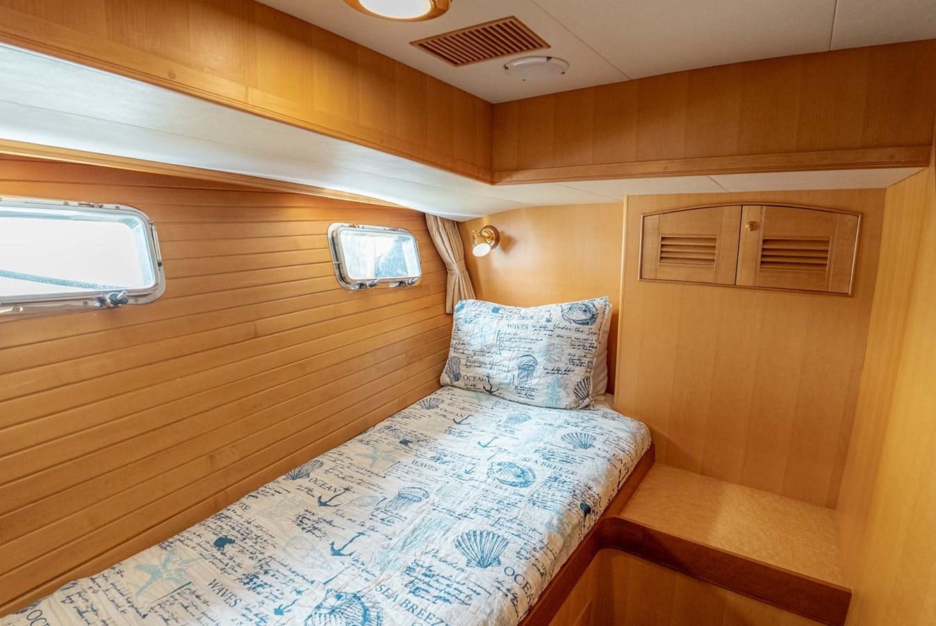 a bed with a blue comforter aboard SOMEDAY CAME Yacht for Sale