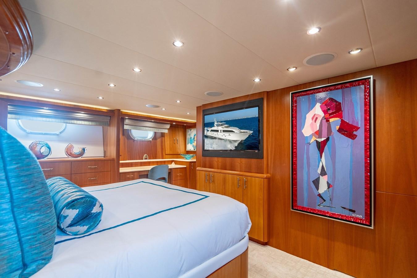 a bedroom with a bed and a painting on the wall aboard INEVITABLE Yacht for Sale