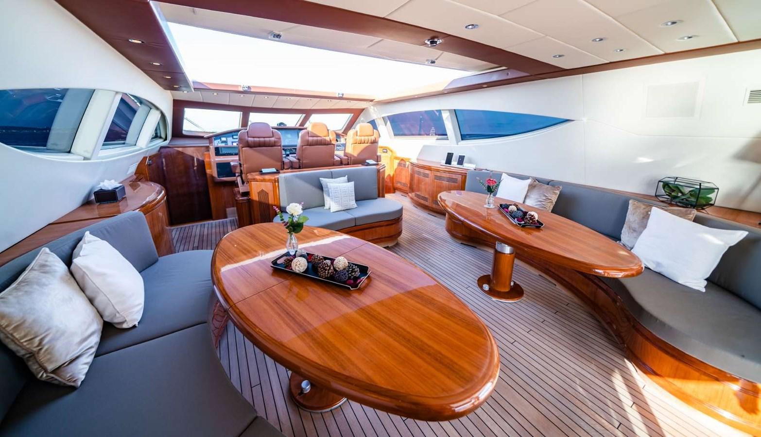a living room with a table and couches aboard STORM Yacht for Sale
