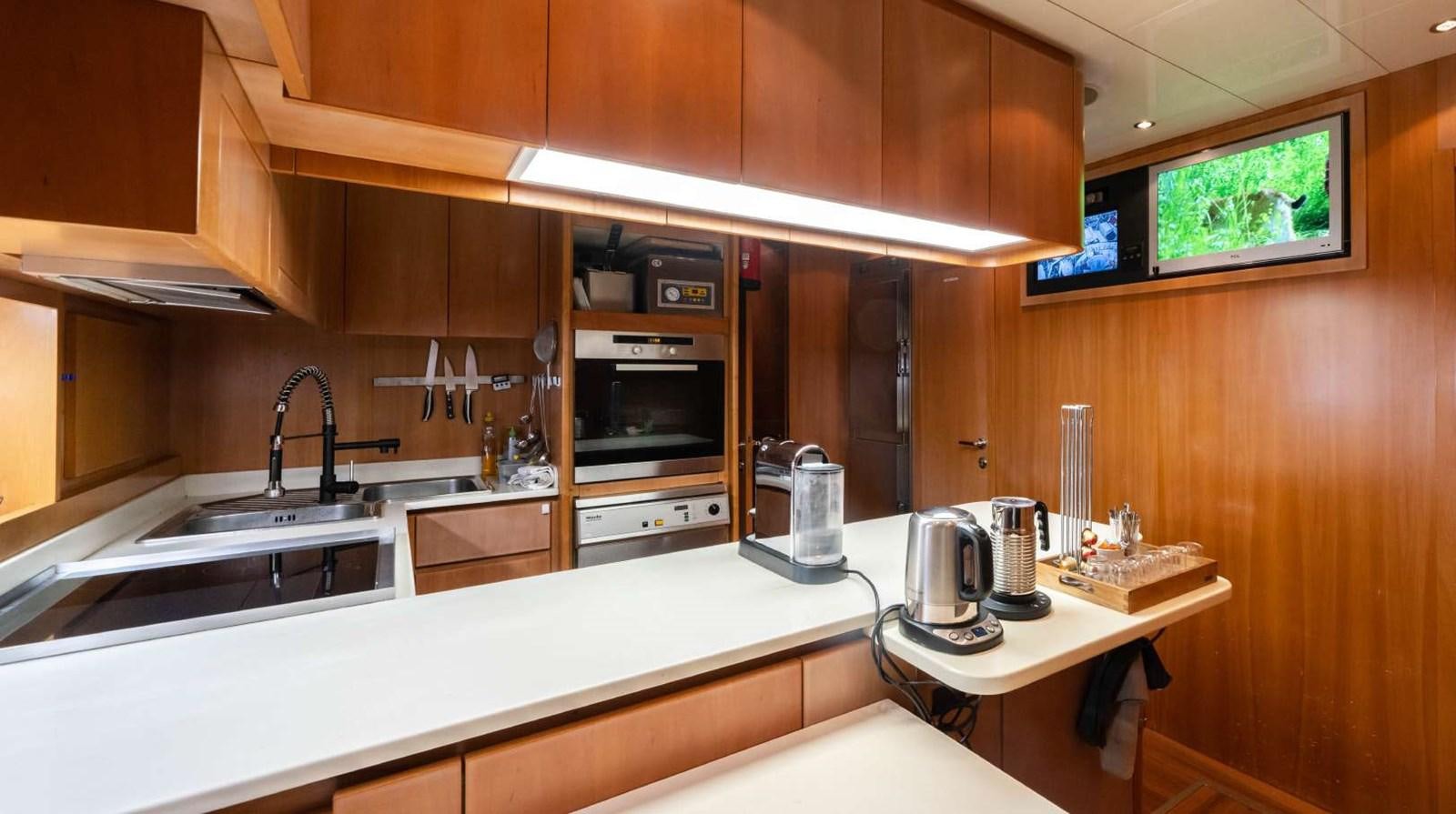 a kitchen with wooden cabinets aboard STORM Yacht for Sale