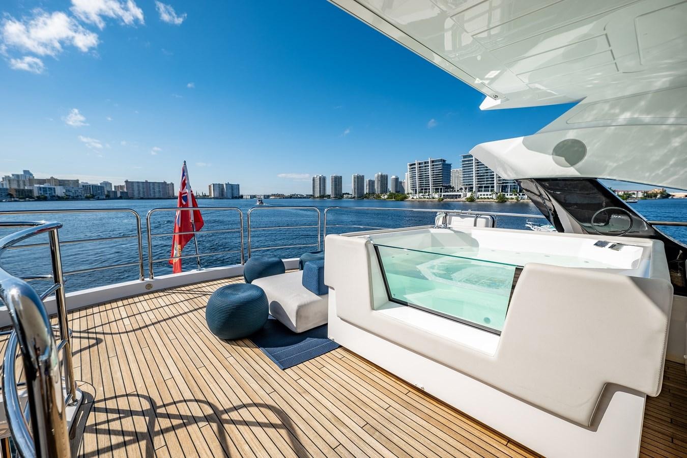 a deck with a pool and a city in the background aboard MANDALA Yacht for Sale
