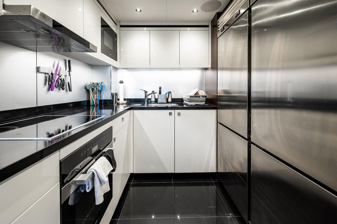 a kitchen with white cabinets aboard MANDALA Yacht for Sale