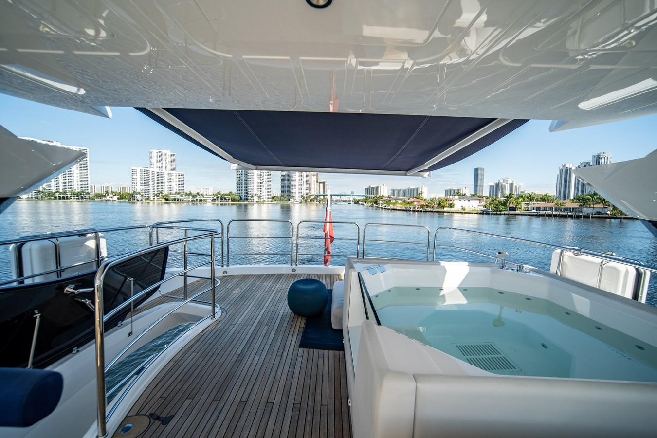 a deck with a pool and a city in the background aboard MANDALA Yacht for Sale