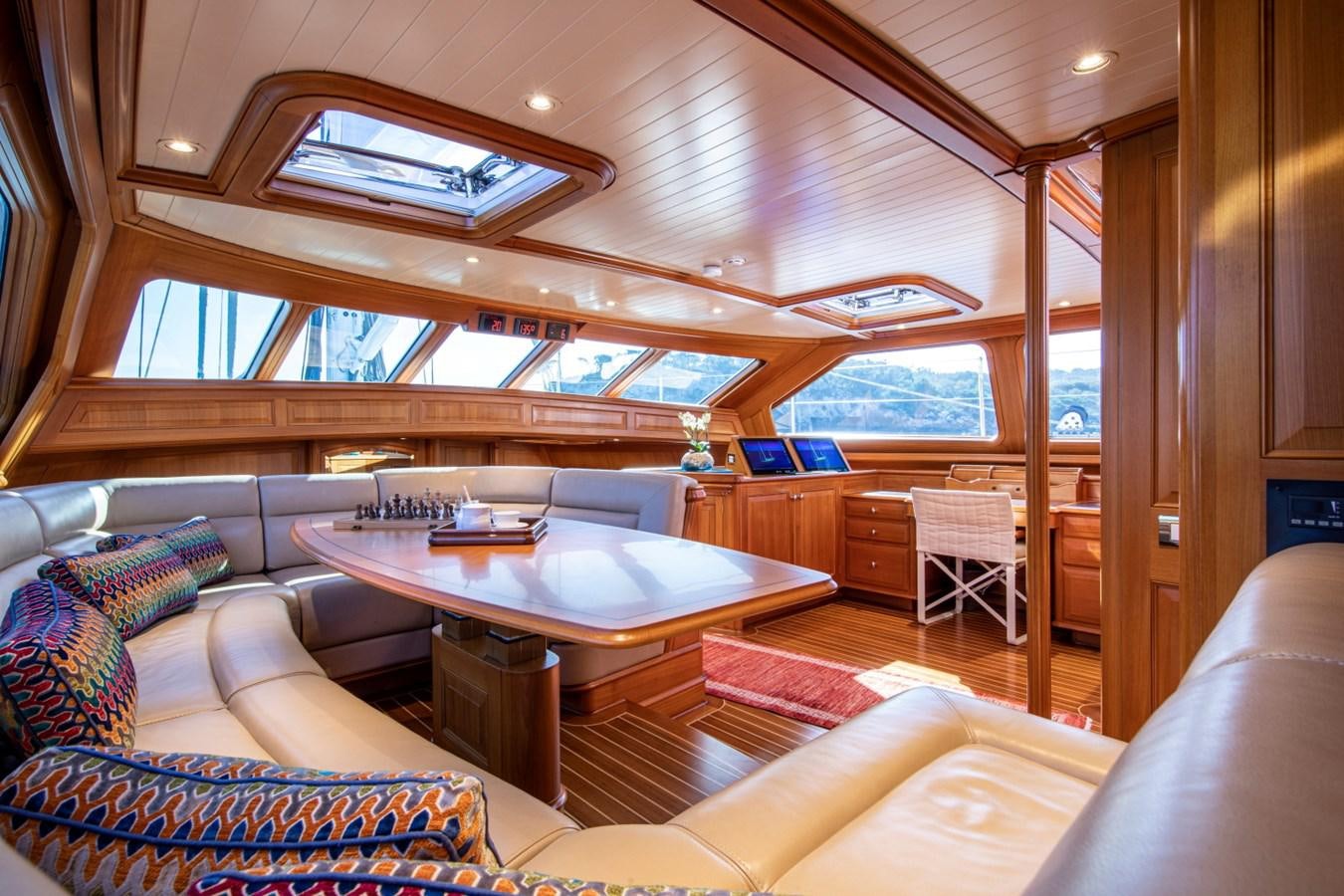 a living room with a table and couches aboard LEGEND Yacht for Sale