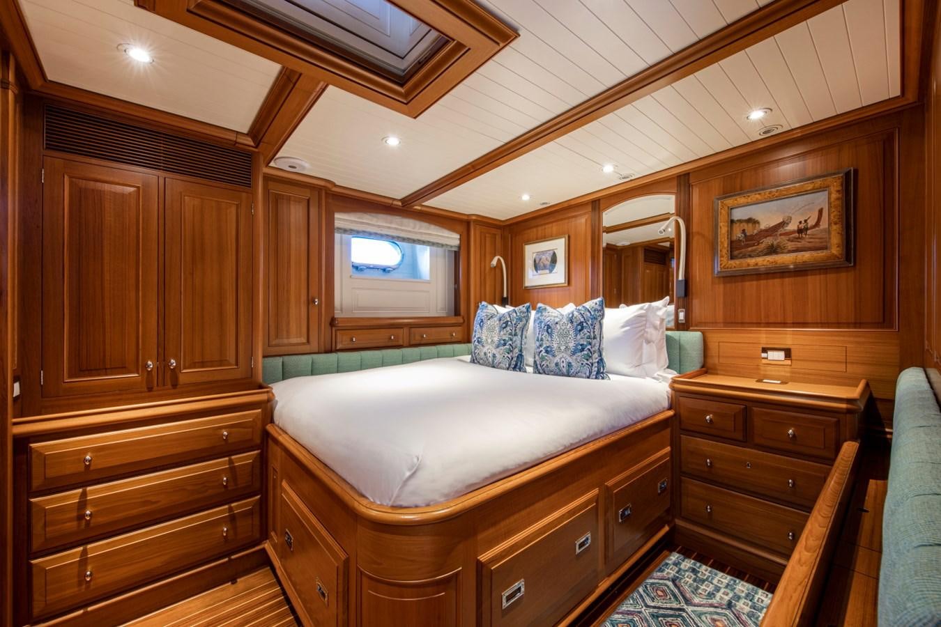 a bedroom with a bed and a dresser aboard LEGEND Yacht for Sale