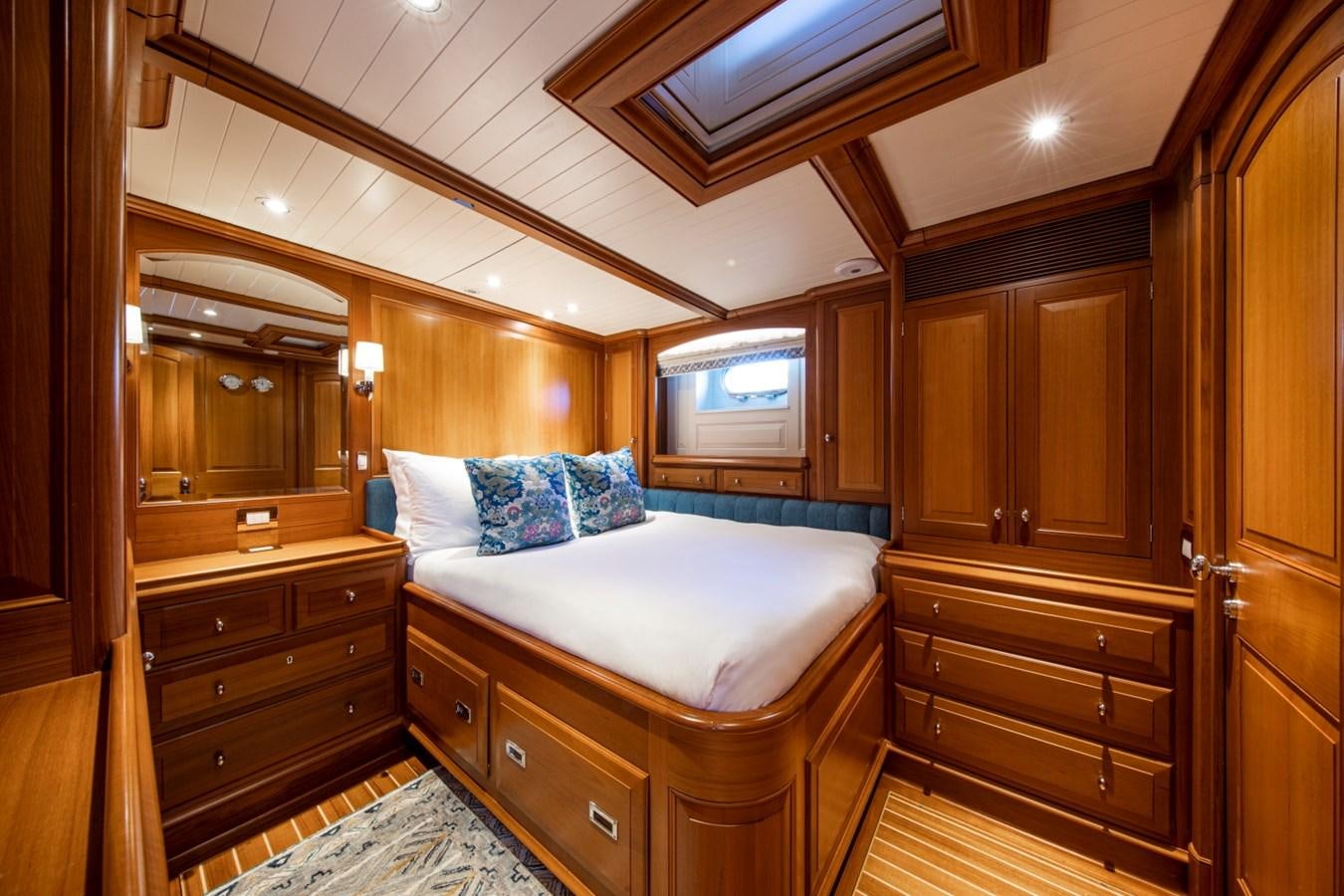 a bedroom with a bed and a dresser aboard LEGEND Yacht for Sale