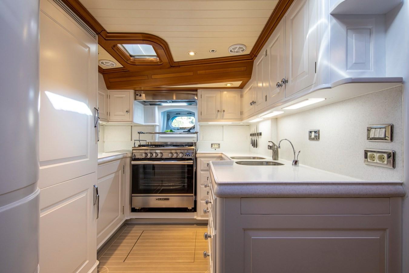 a kitchen with white cabinets aboard LEGEND Yacht for Sale