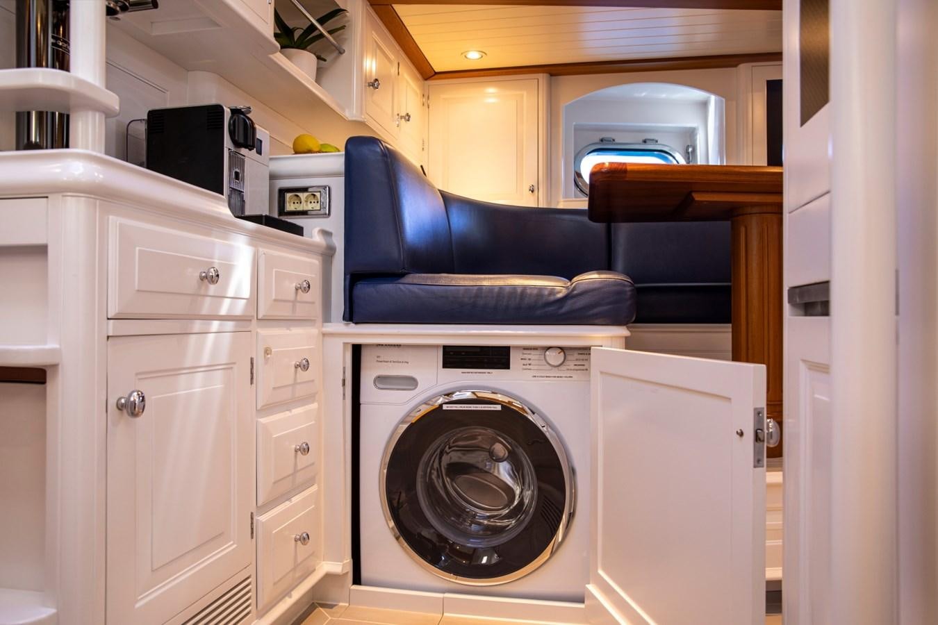 a room with a washing machine and a chair aboard LEGEND Yacht for Sale