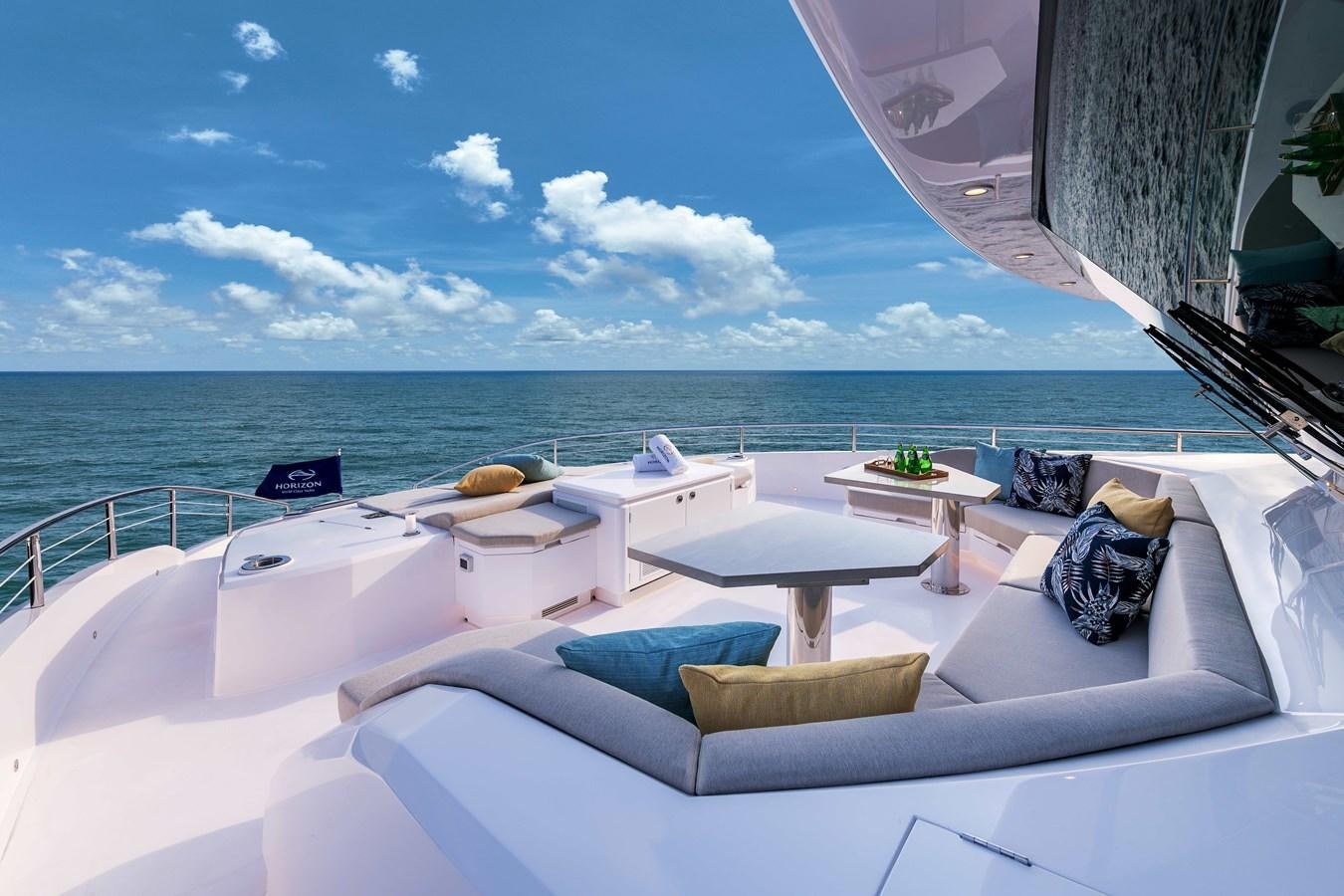 a lounge area with a bed and a table on it aboard HORIZON FD100/911 Yacht for Sale