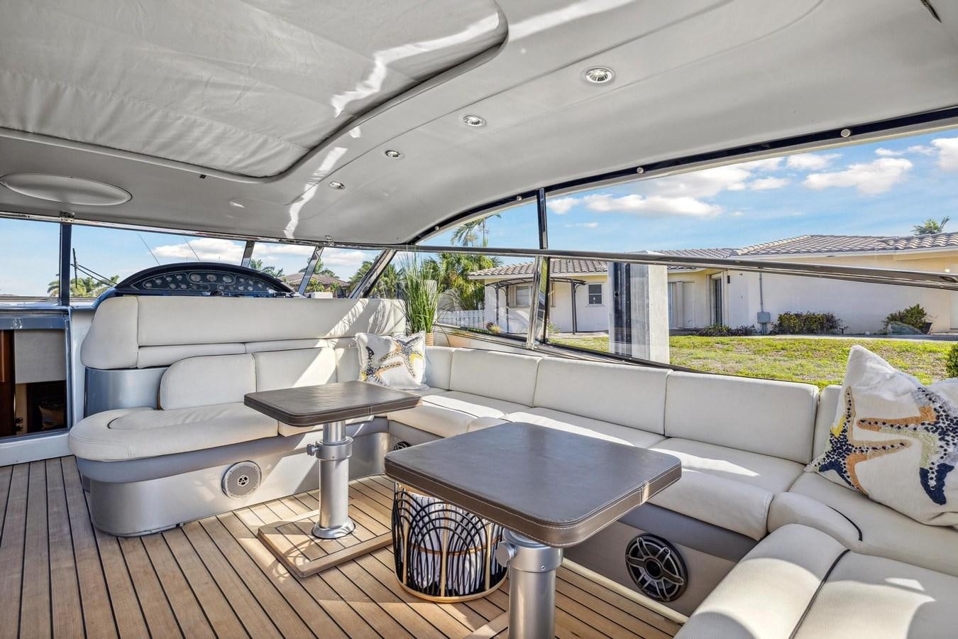 a white lounge chair and a table on a deck with a view of the water and a large aboard ALCHEMY Yacht for Sale