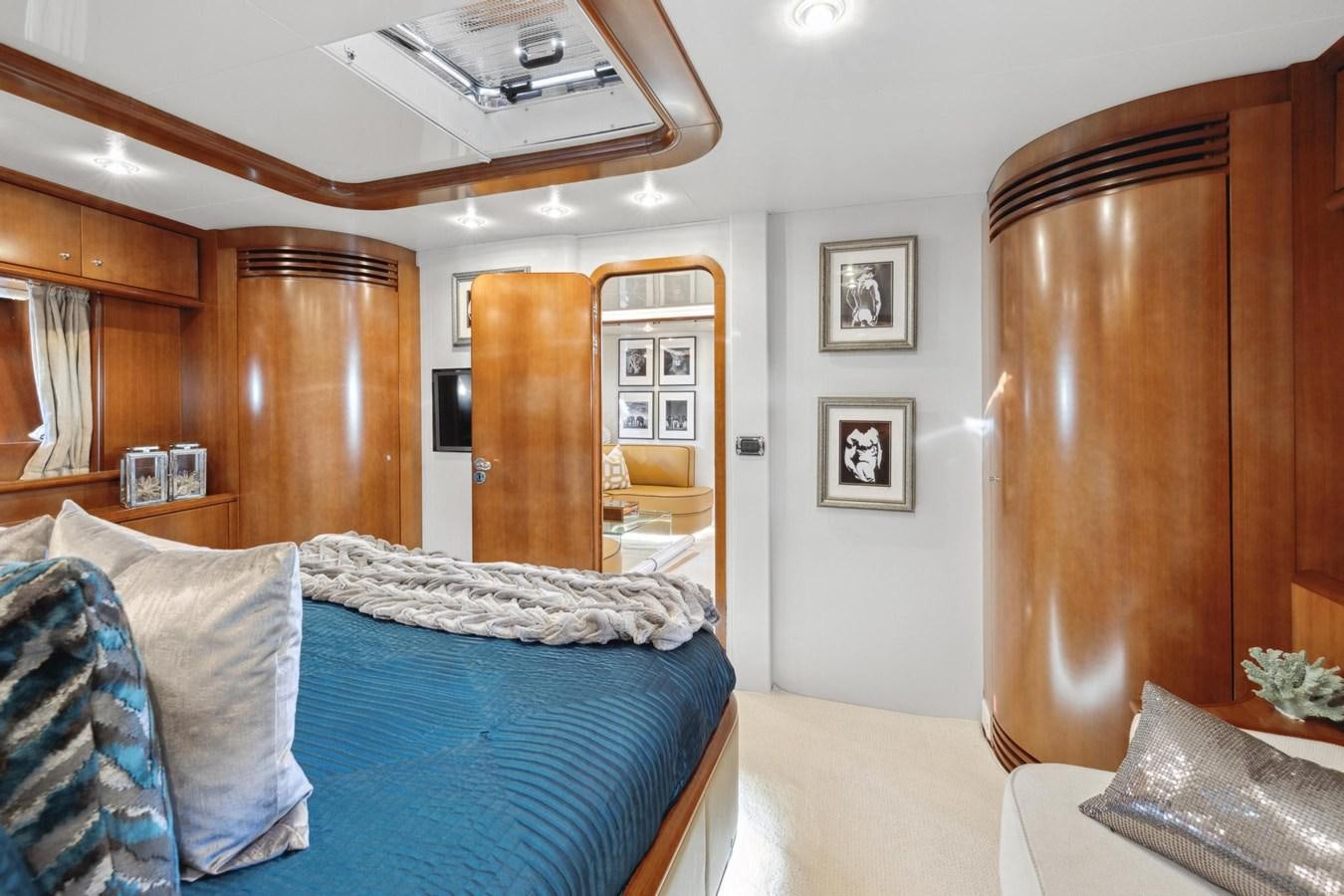 a bedroom with a bed and a wood cabinet aboard ALCHEMY Yacht for Sale