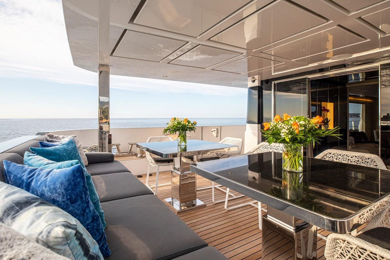 a living room with a large glass table and a view of the ocean aboard CINQUANTA-50 Yacht for Sale