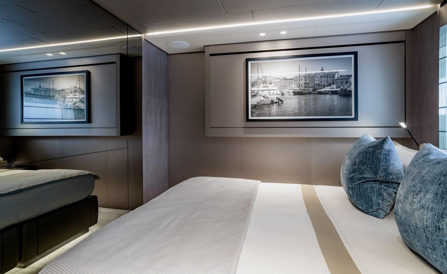 a room with a bed and a television on the wall aboard TOGETHER Yacht for Sale