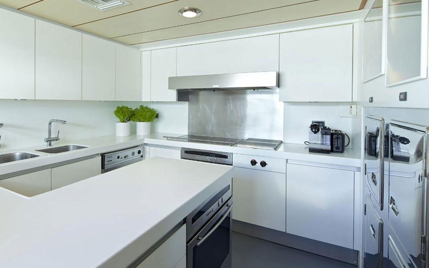 a kitchen with white cabinets aboard AQUAJOY Yacht for Sale