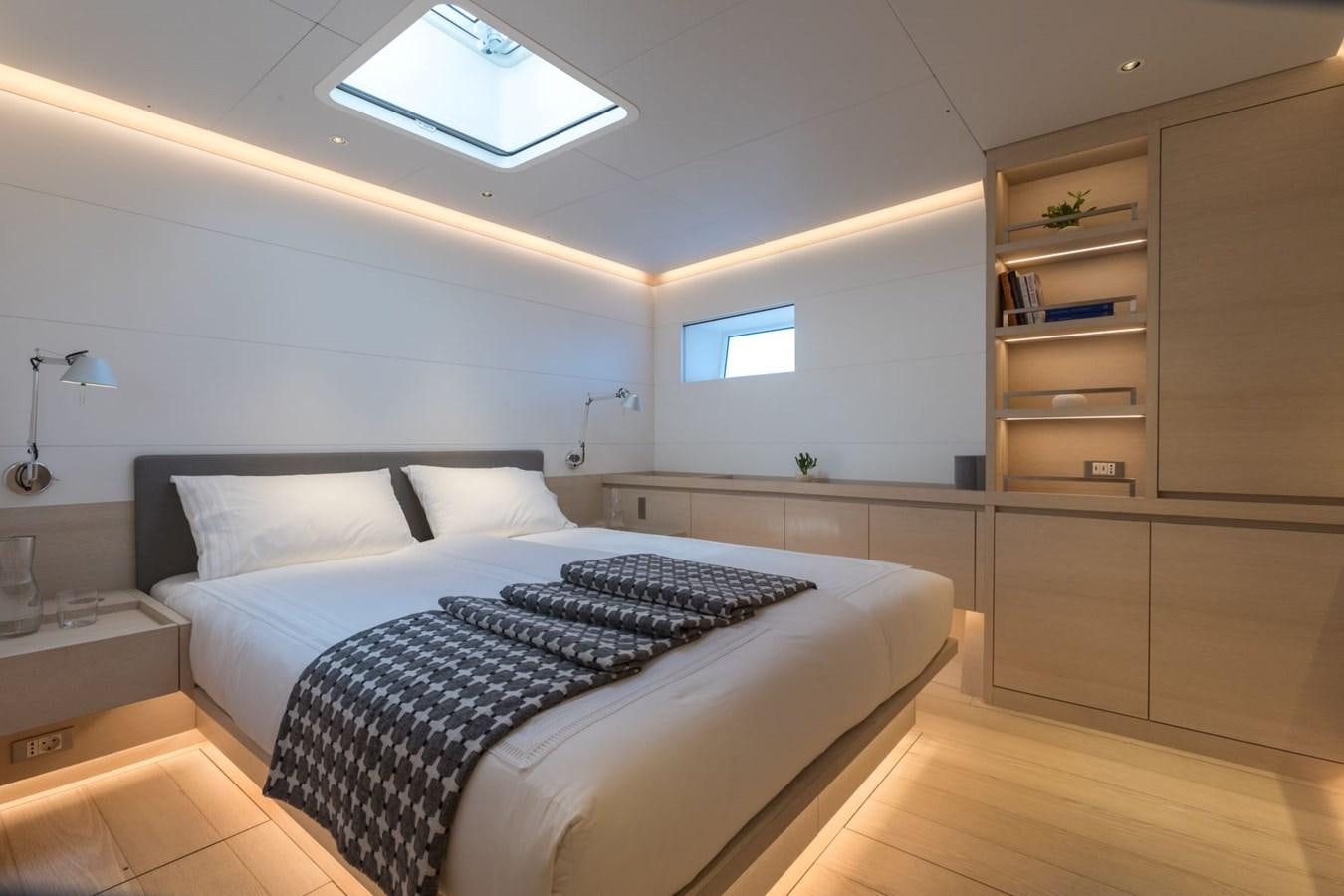 a bedroom with a bed and a shelf aboard CERVO Yacht for Sale