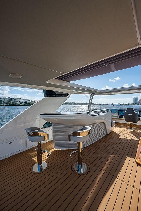 a room with a table and chairs on a deck overlooking a body of water aboard 68 NAVETTA  Yacht for Sale