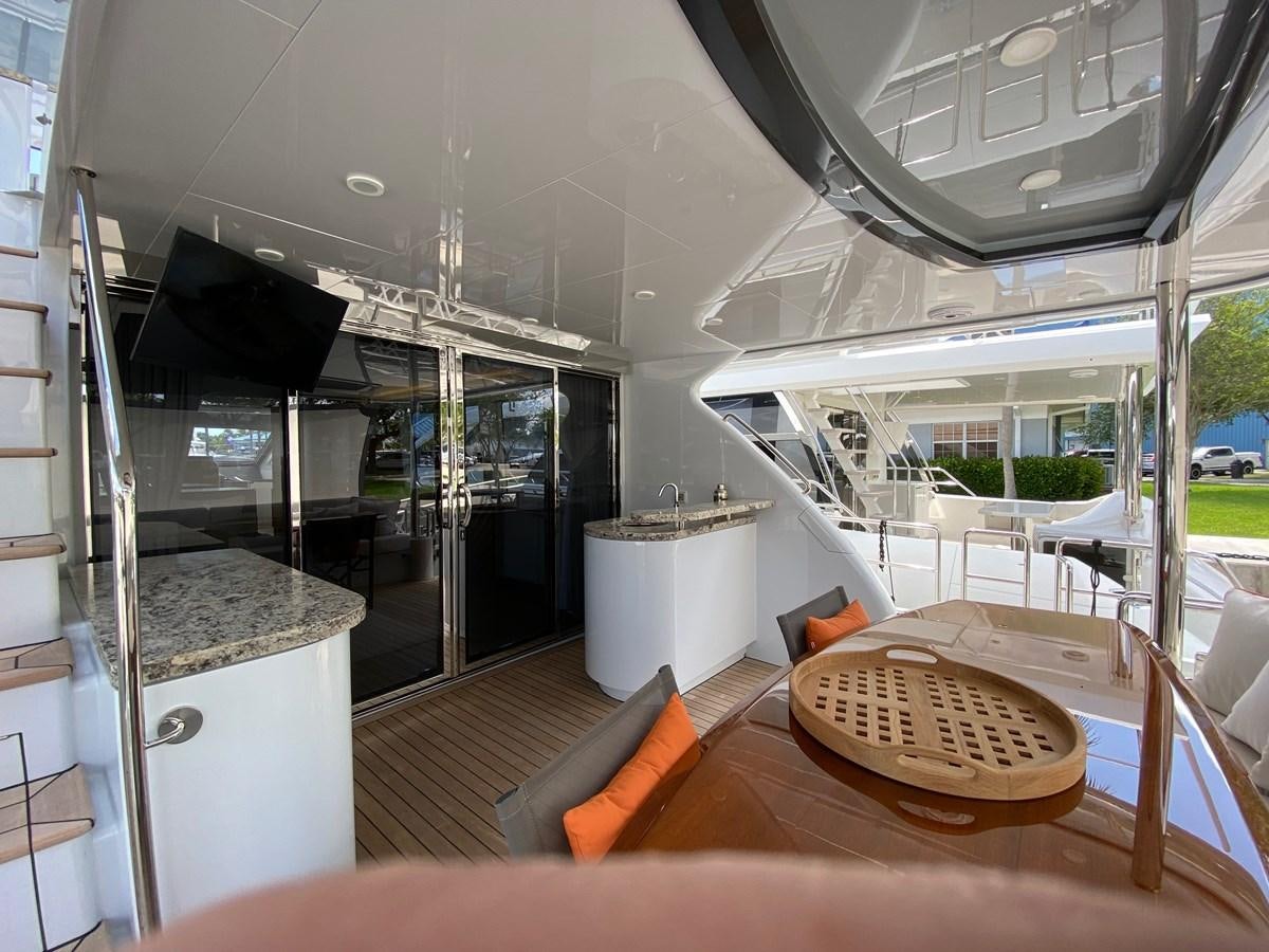 a modern looking kitchen with a large glass door and a wood table aboard CLB72 Yacht for Sale