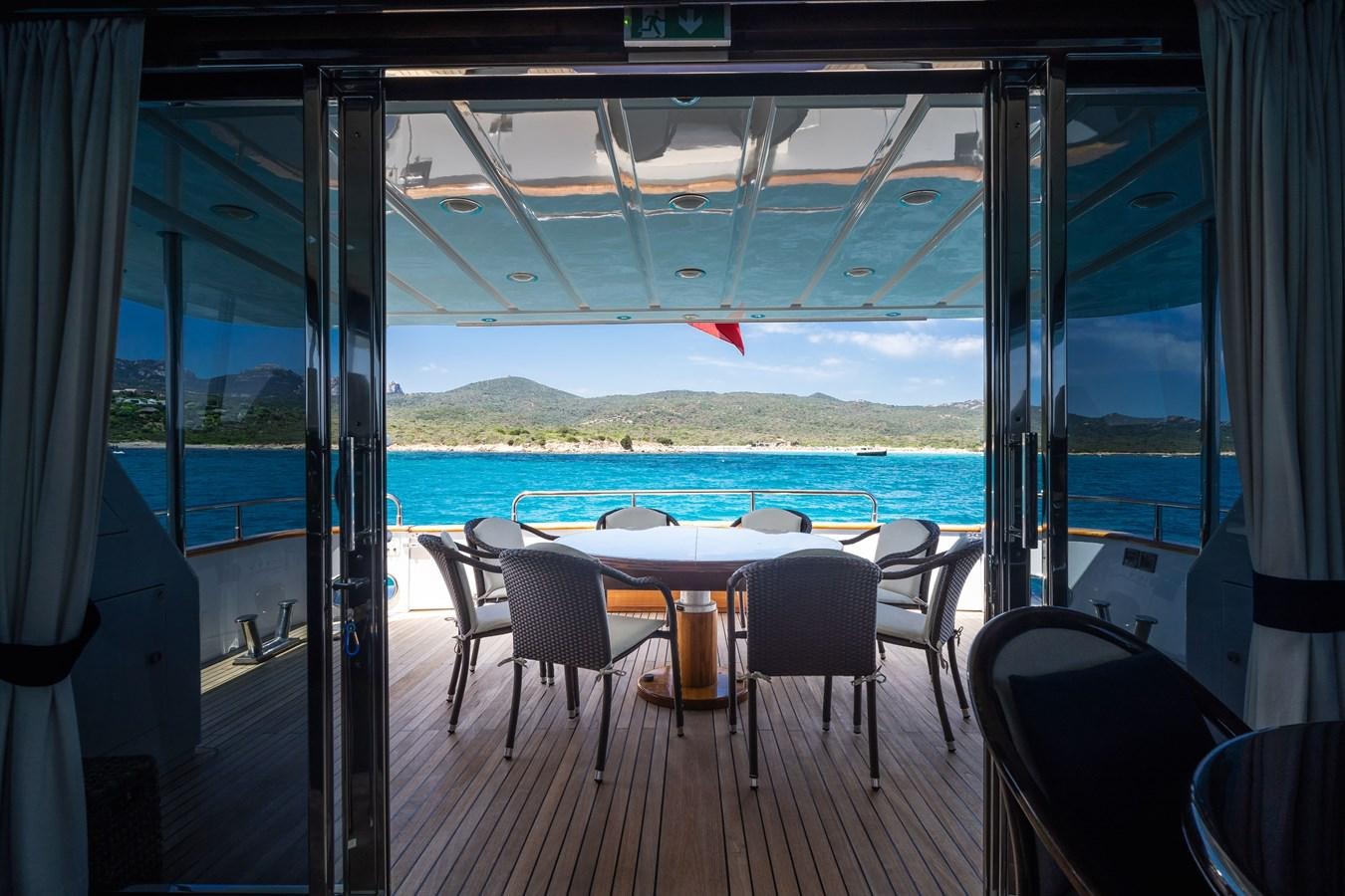a room with a table and chairs and a view of the ocean aboard ALEDOUTHO Yacht for Sale