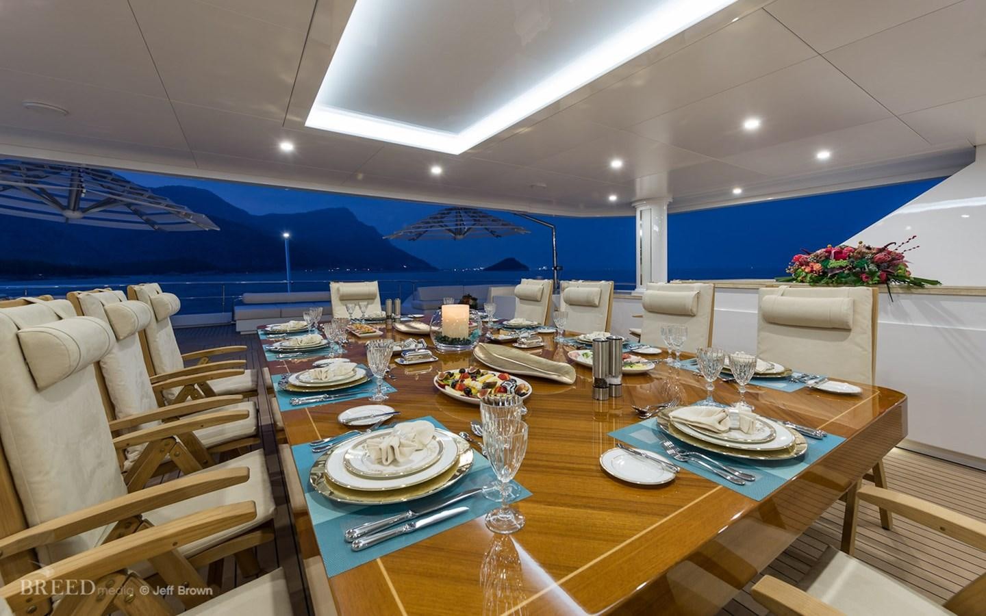 a large table with plates and glasses aboard ALMAX Yacht for Sale