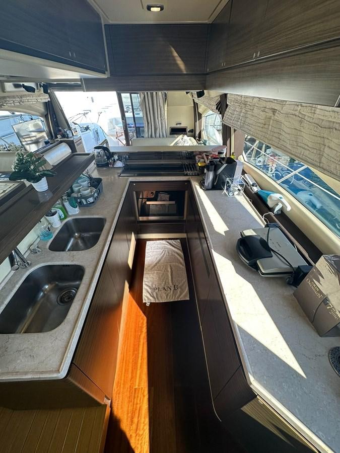 a kitchen with a sink and a large window aboard AZIMUT 64 FLY 2014 Yacht for Sale