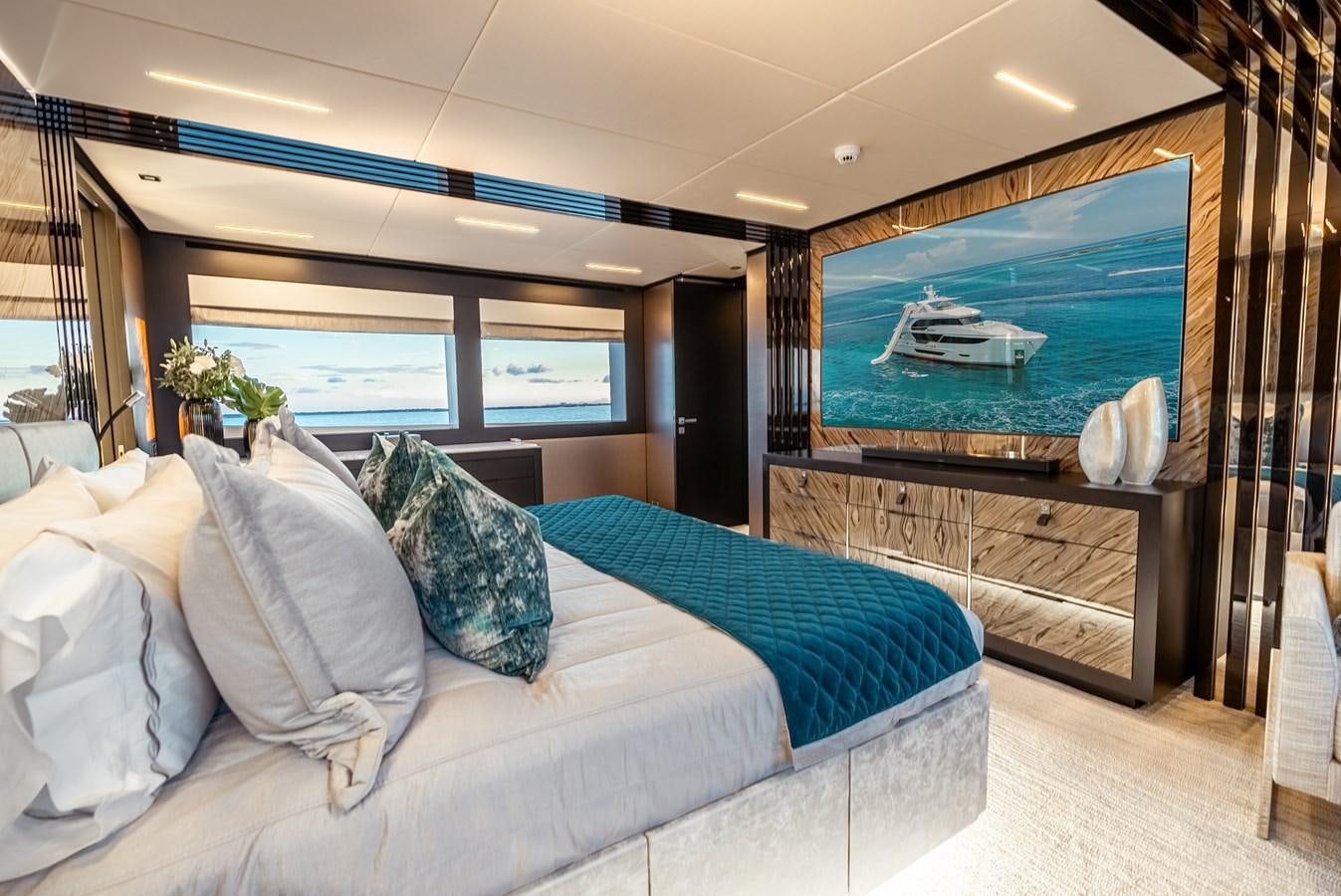 a large living room with a large blue bed aboard ROMEO FOXTROT Yacht for Sale