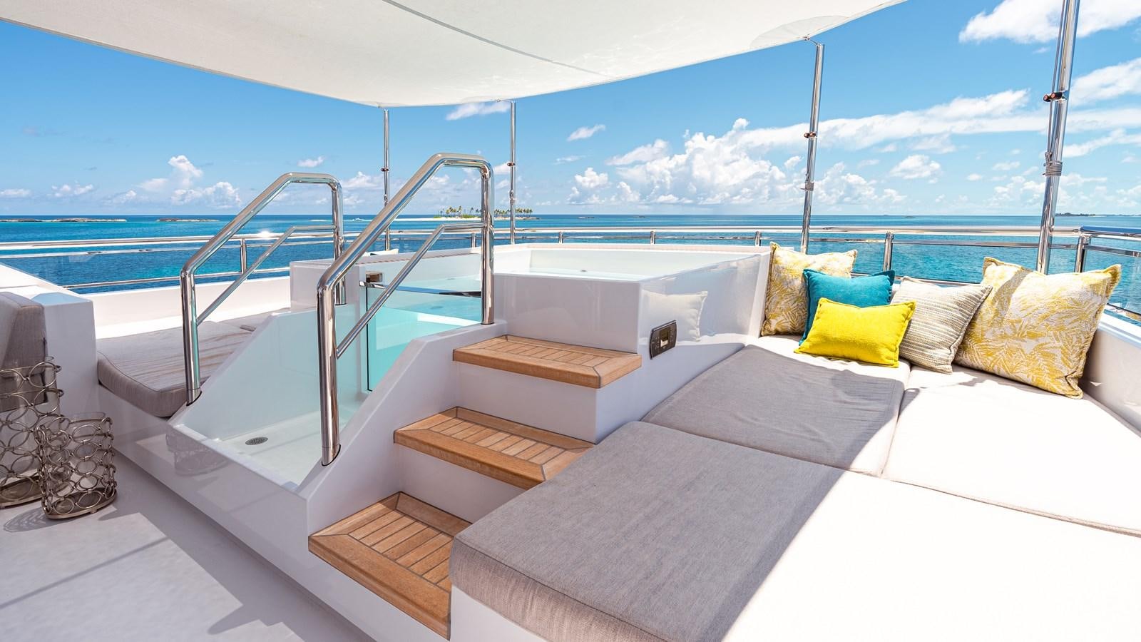 a bed with a white bed and a white couch aboard ROMEO FOXTROT Yacht for Sale