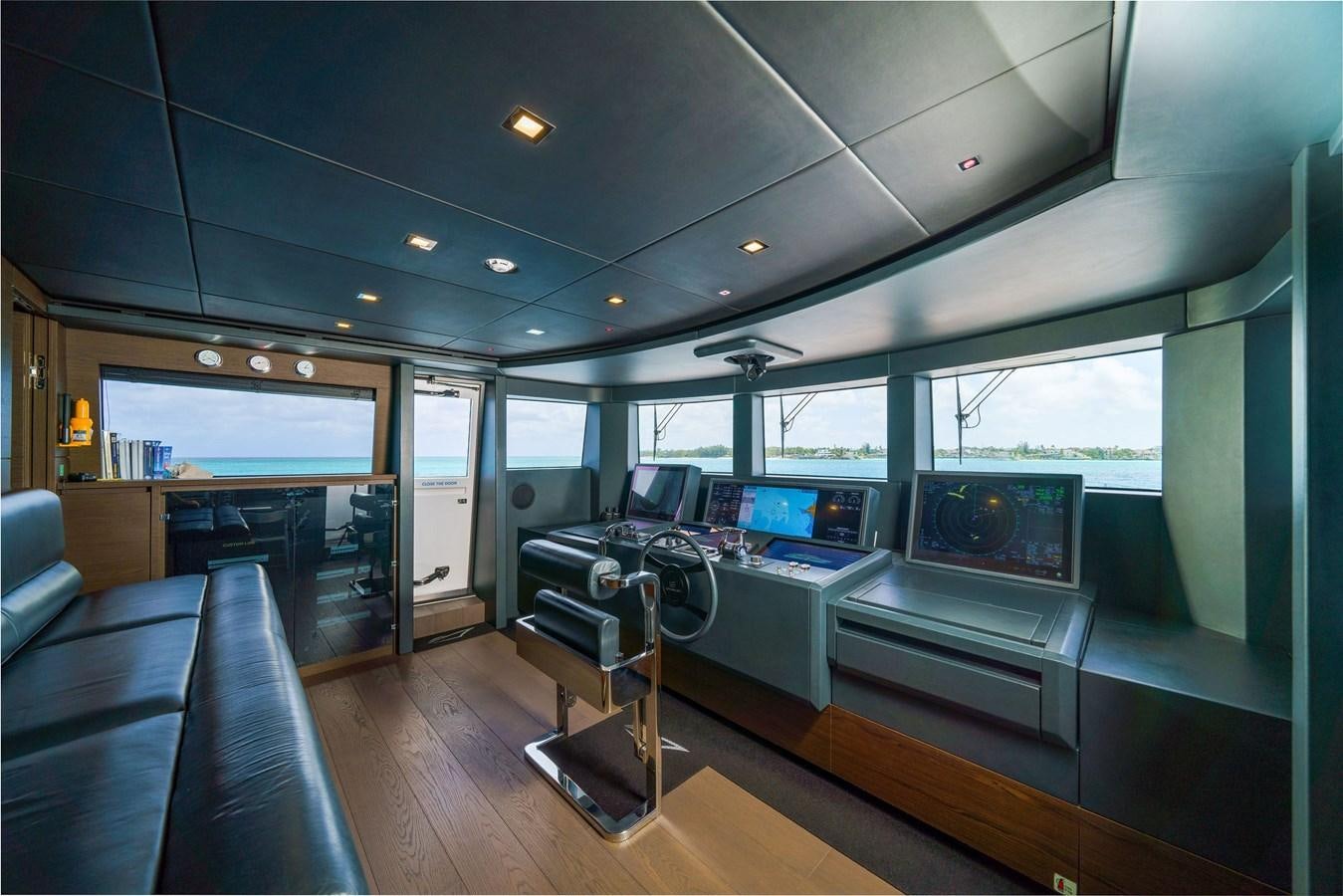 a room with a large window and a table with chairs and a television aboard ASANTE Yacht for Sale