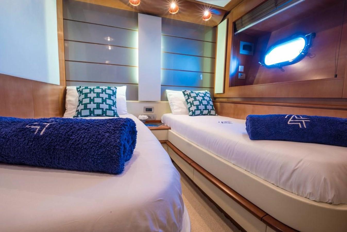 a room with beds and a tv aboard 4F Yacht for Sale