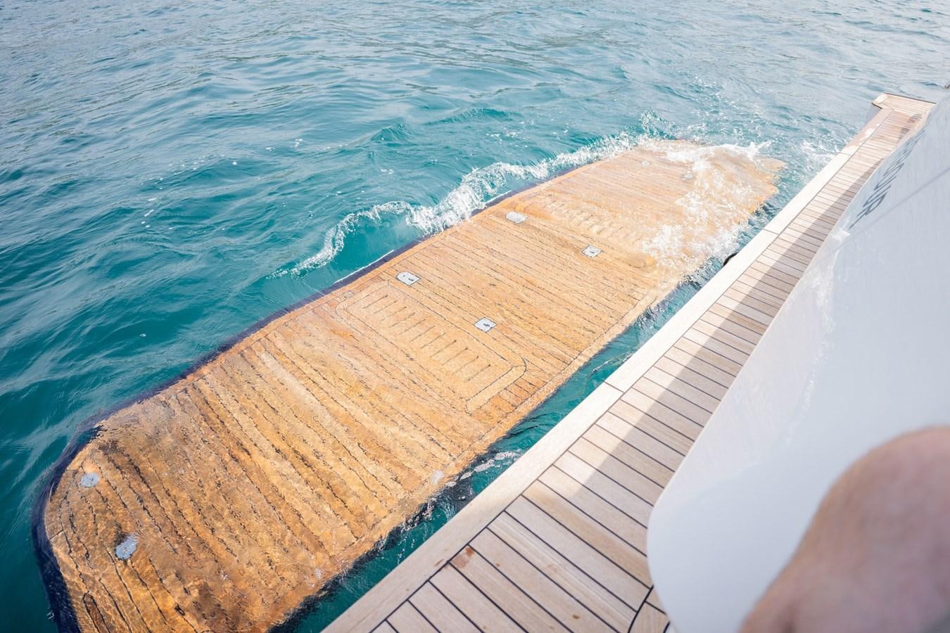 a wooden dock over the water aboard PICHOS III Yacht for Sale