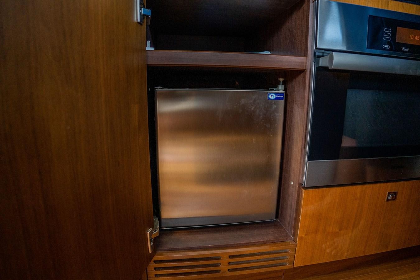 a kitchen with wooden cabinets aboard PICHOS III Yacht for Sale