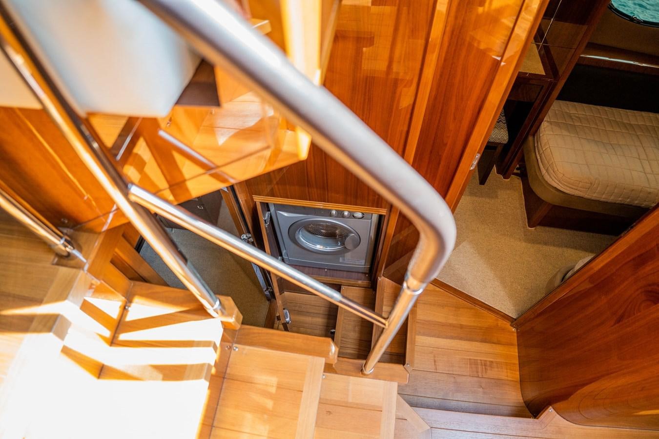a wooden staircase with a round black object on top aboard PICHOS III Yacht for Sale