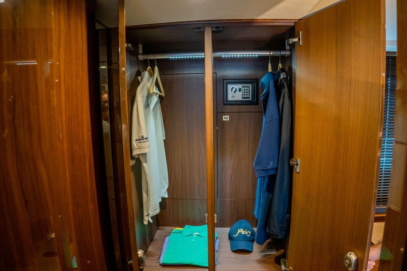 a closet with clothes on the wall aboard PICHOS III Yacht for Sale