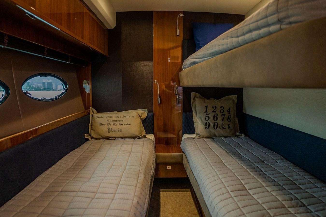 a room with beds and a wood door aboard PICHOS III Yacht for Sale
