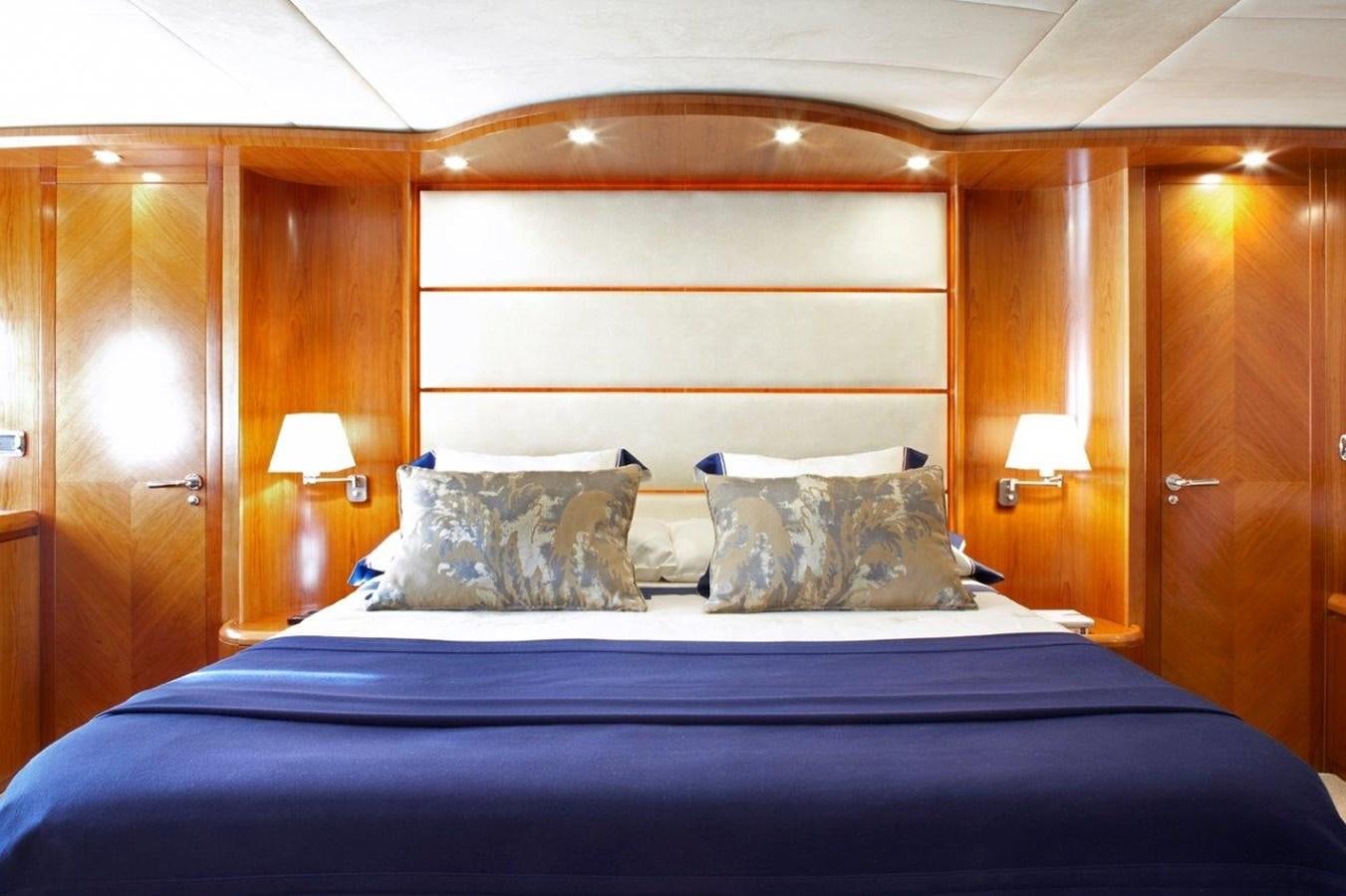 a bed with a blue comforter aboard BARBASILDA Yacht for Sale