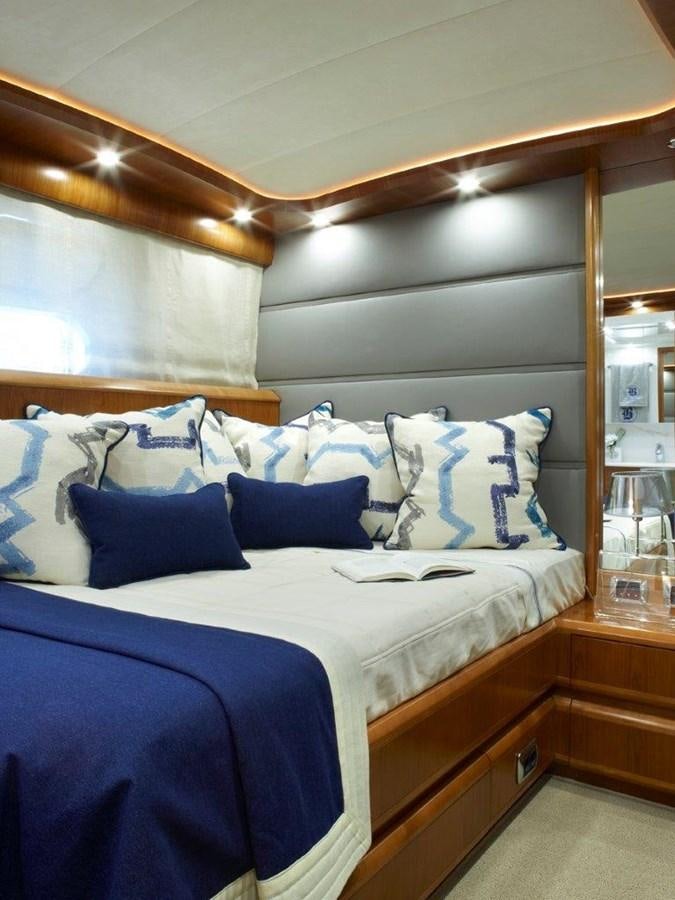 a bed with blue and white sheets aboard BARBASILDA Yacht for Sale