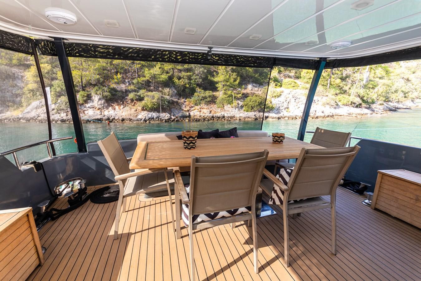 a table and chairs on a deck aboard WATER Yacht for Sale