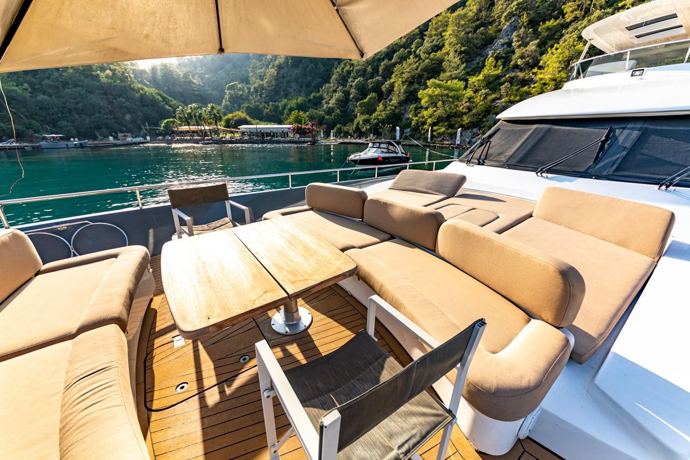 a room with a table chairs and a body of water in the background aboard WATER Yacht for Sale