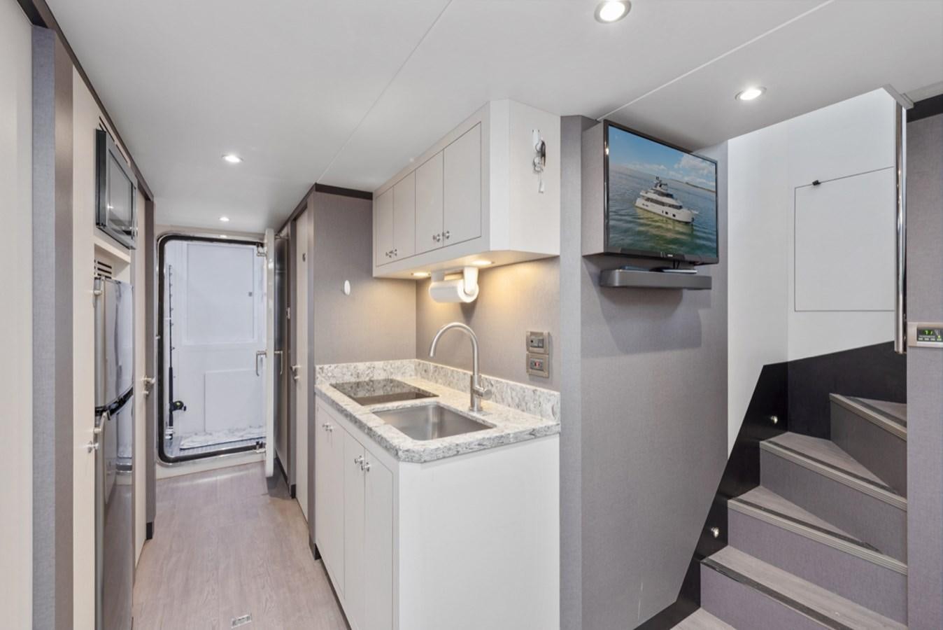 a kitchen with white cabinets aboard EVERGLADE Yacht for Sale