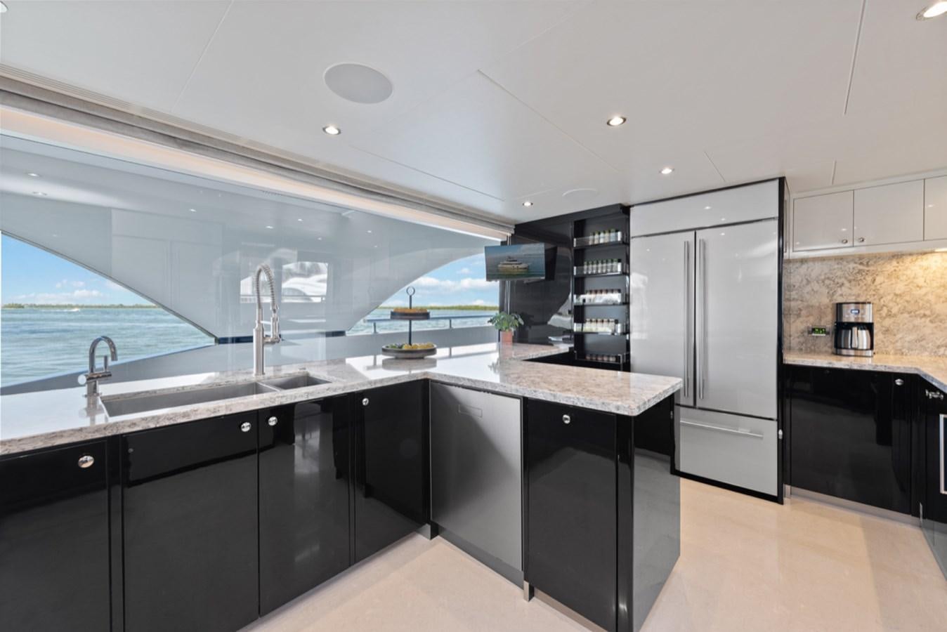 a kitchen with black cabinets aboard EVERGLADE Yacht for Sale