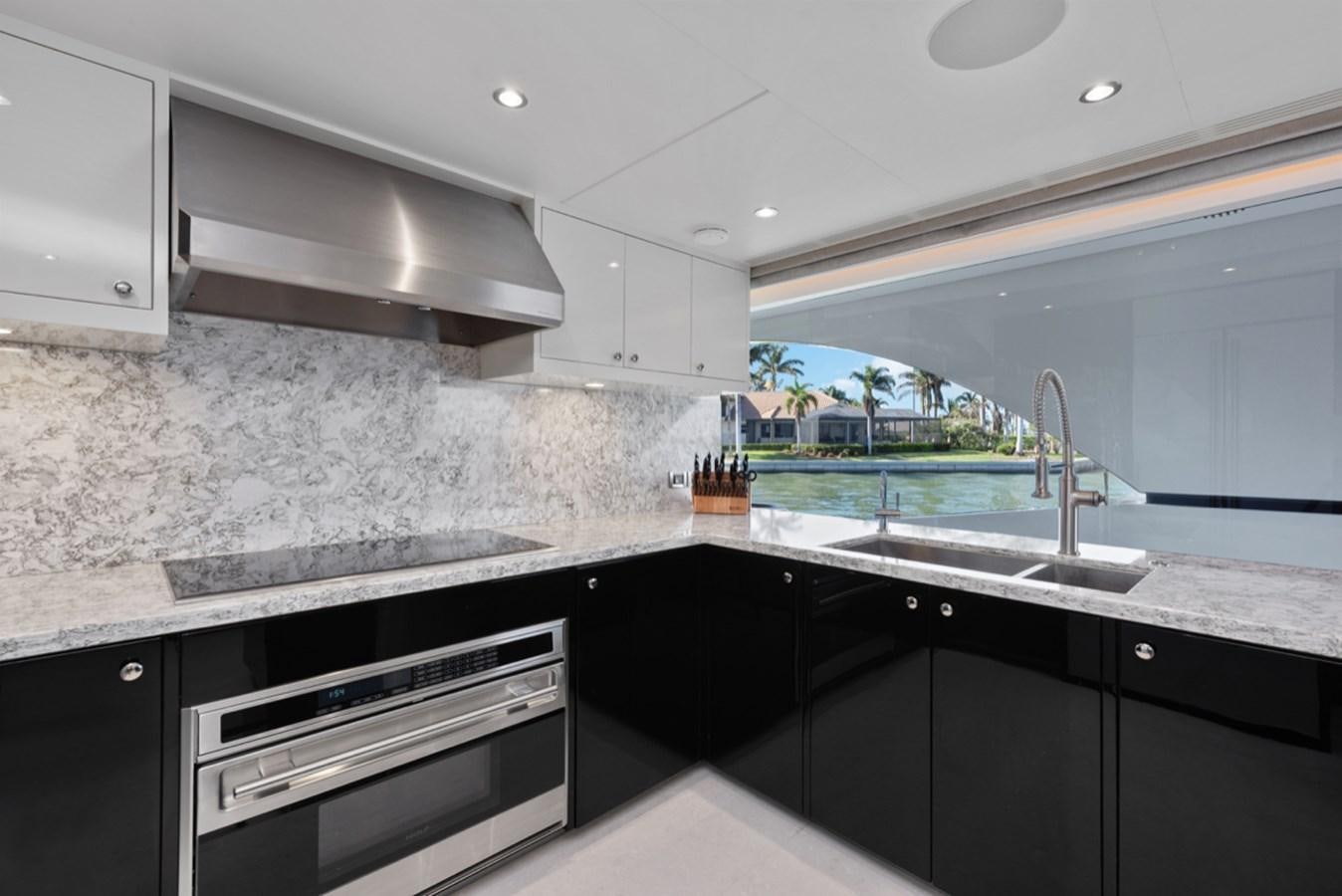 a kitchen with black cabinets aboard EVERGLADE Yacht for Sale