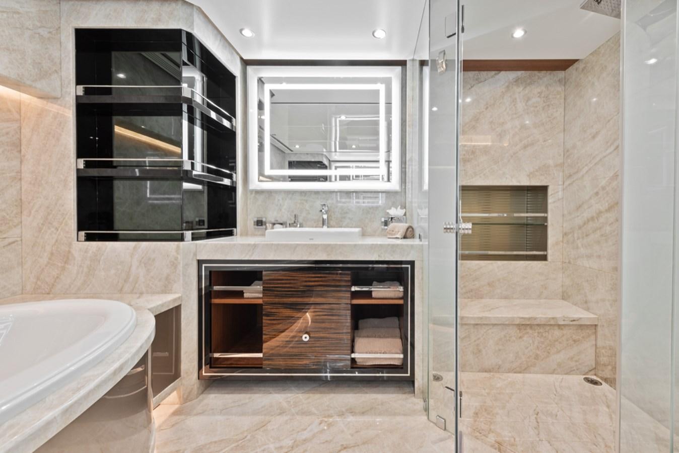 a bathroom with a tub sink and cabinets aboard EVERGLADE Yacht for Sale