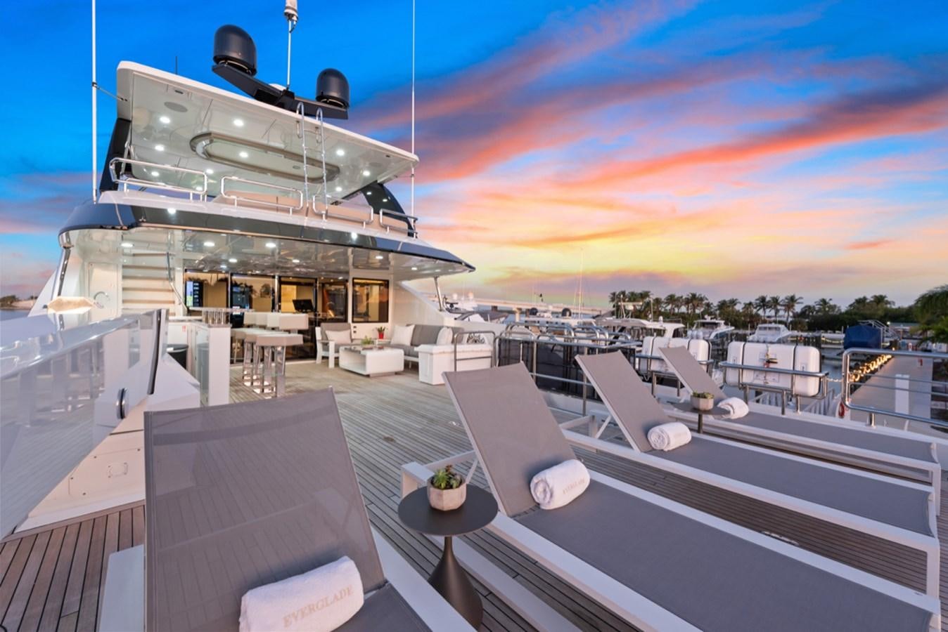a large space ship with a deck and a deck with chairs and a sunset aboard EVERGLADE Yacht for Sale
