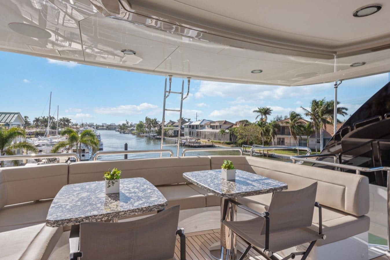 a table and chairs on a patio aboard EVERGLADE Yacht for Sale