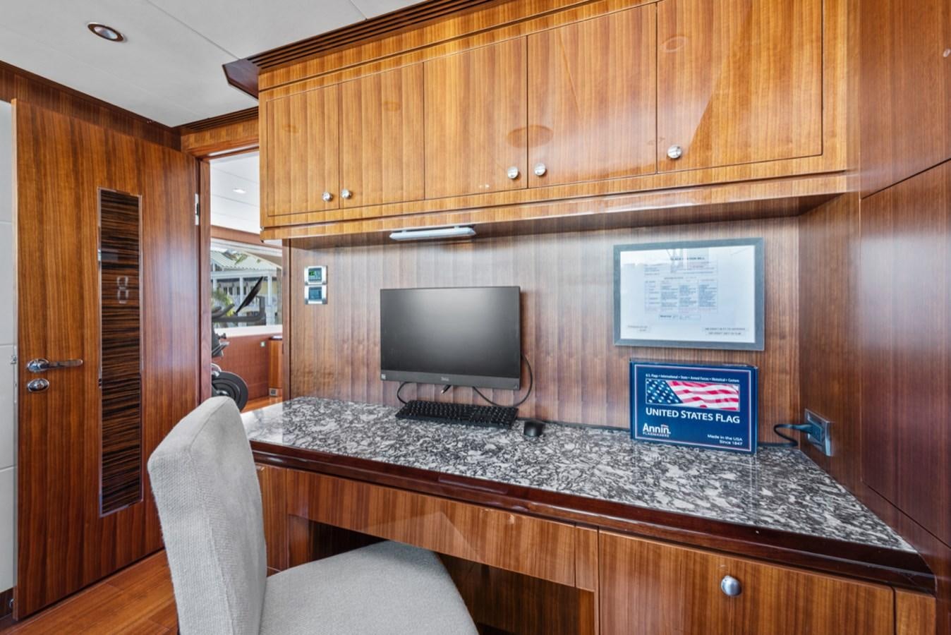 a kitchen with a tv and cabinets aboard EVERGLADE Yacht for Sale