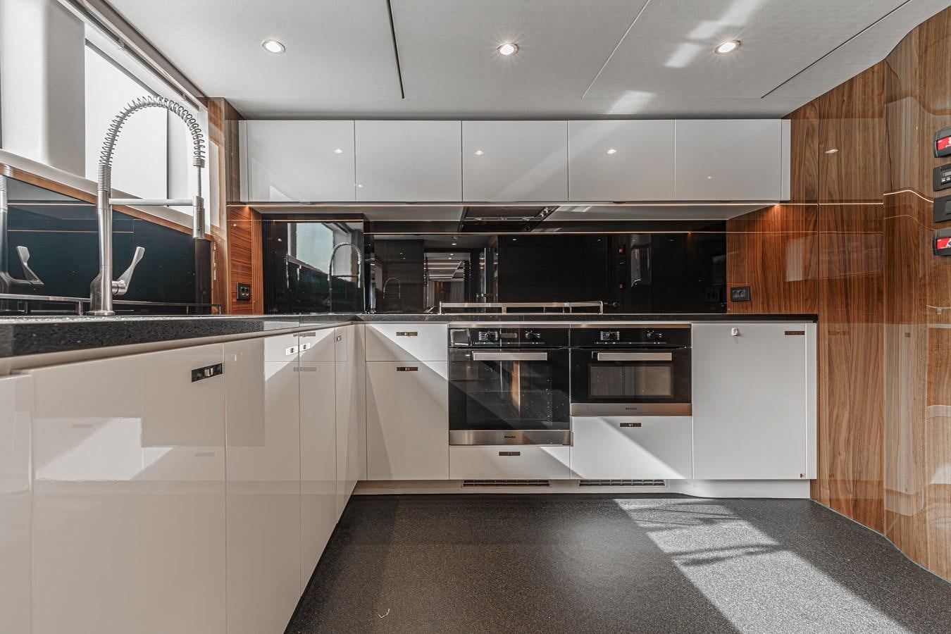 a kitchen with black appliances aboard AVALON Yacht for Sale