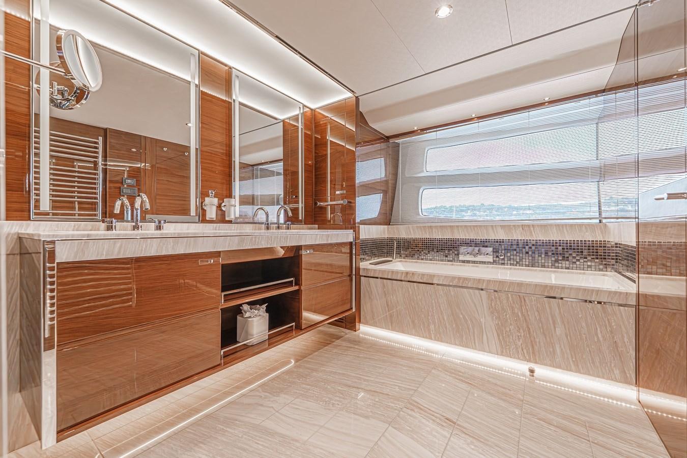 a large bathroom with wooden cabinets aboard AVALON Yacht for Sale