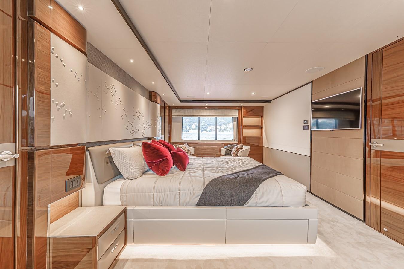 a bedroom with a bed and a window aboard AVALON Yacht for Sale