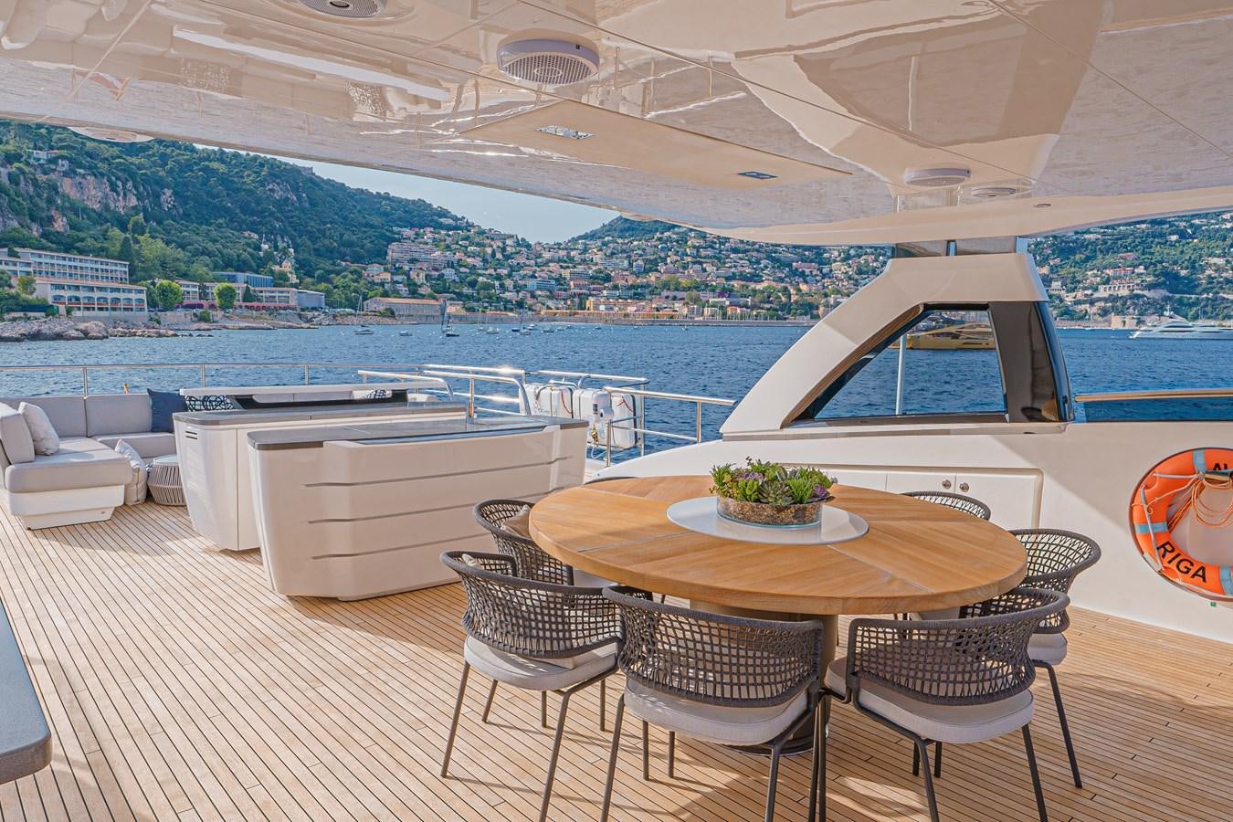 a table and chairs on a deck overlooking a large body of water aboard AVALON Yacht for Sale