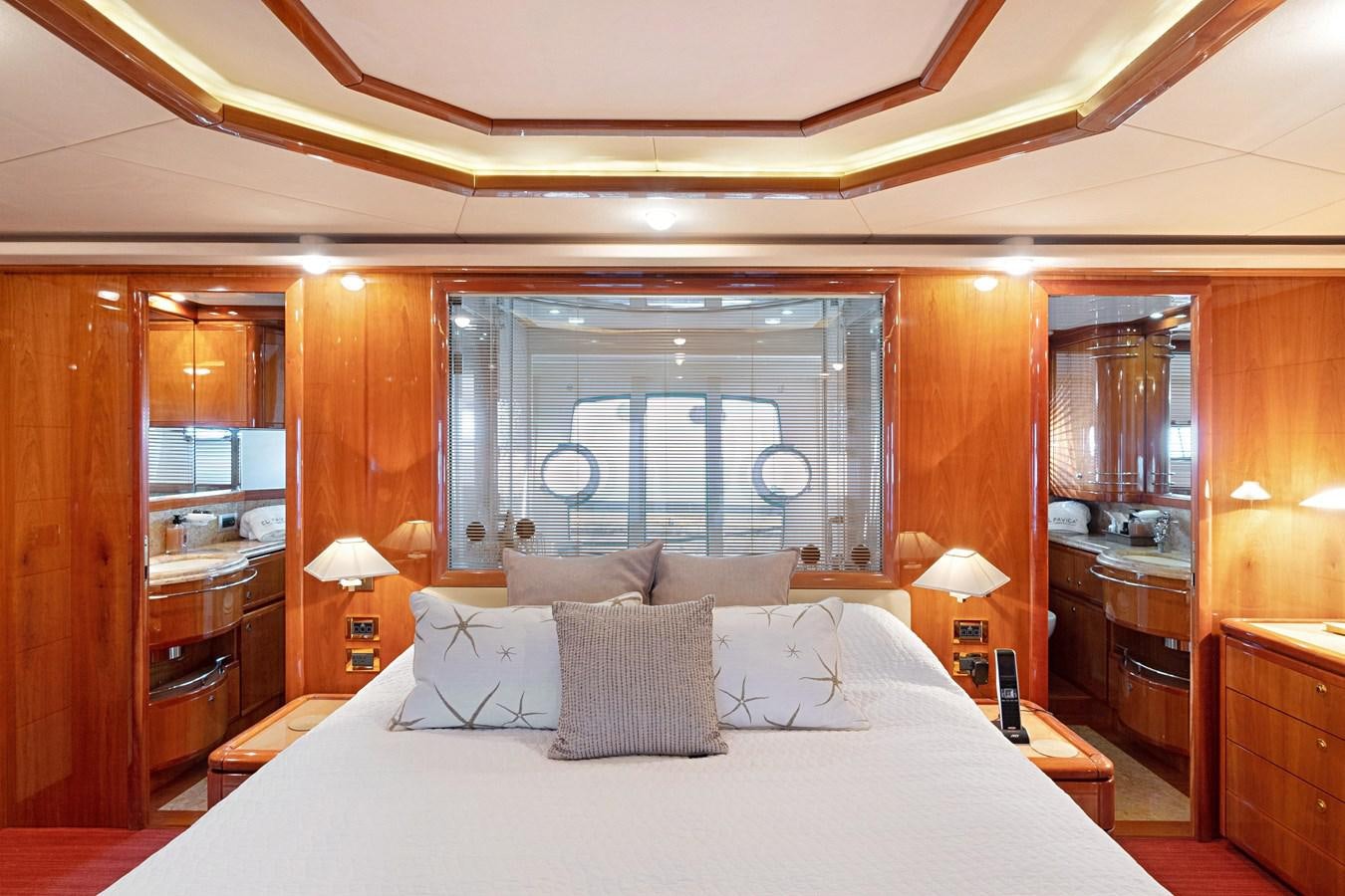 a bed with pillows and a mirror aboard EL PAVICA Yacht for Sale