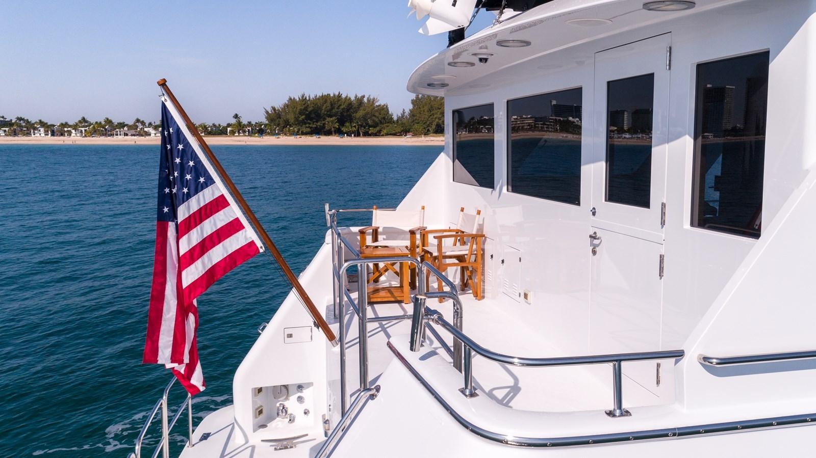 a boat with a flag on it aboard WELL DONE Yacht for Sale